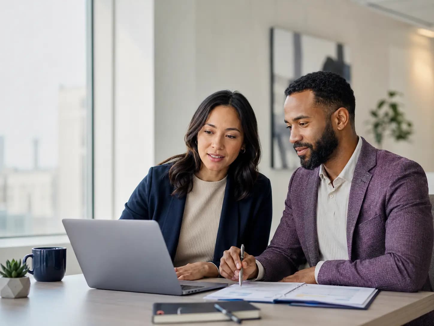 Credentialing specialist reviewing provider enrollment requirements with a healthcare practice administrator